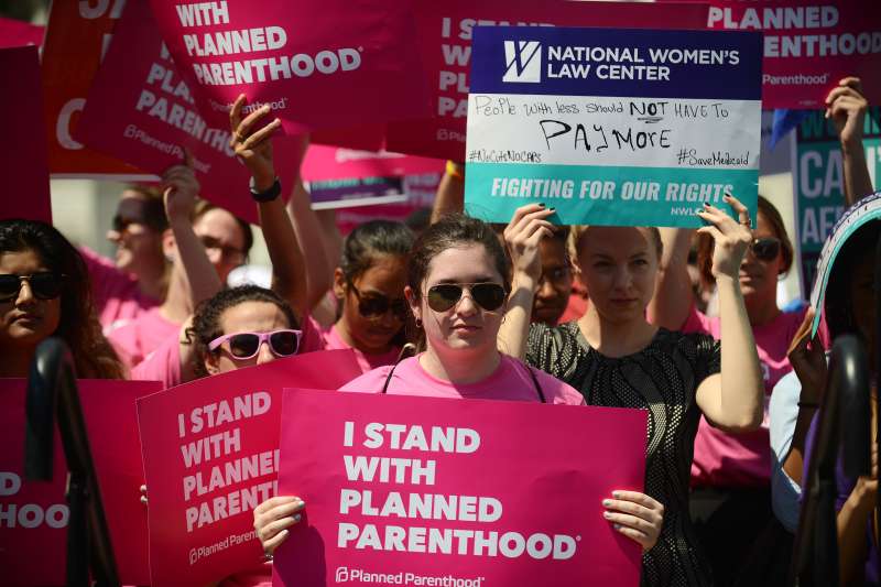 Protesters hold posters in support of Planned Parenthood at a rally to oppose the repeal of the Affordable Care Act and its replacement on Capitol Hill on June 21, 2017 in Washington, DC.