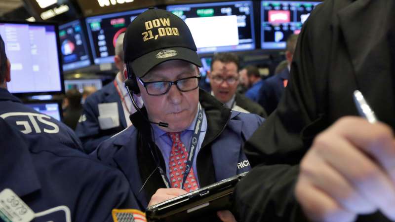 In this Wednesday, March 1, 2017, file photo, trader Richard Cohen wears a  Dow 21,000  cap as he works on the floor of the New York Stock Exchange. Excitement that President Donald Trump will drive business-friendly policies is only one of the reasons behind the stock market’s recent surge.