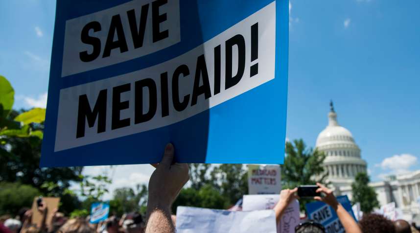 Participants hold signs during the Senate Democrats' rally against Medicaid cuts in front of the U.S. Capitol on Tuesday, June 6, 2017.