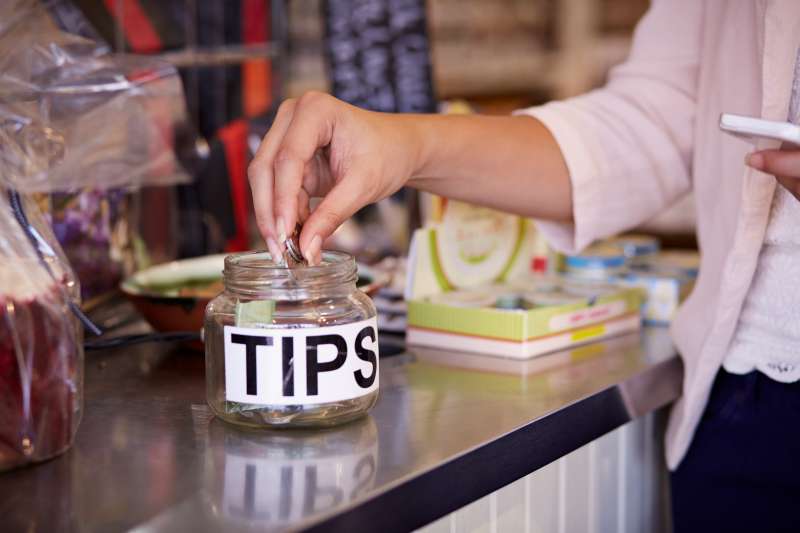 Close-up of woman tipping at café