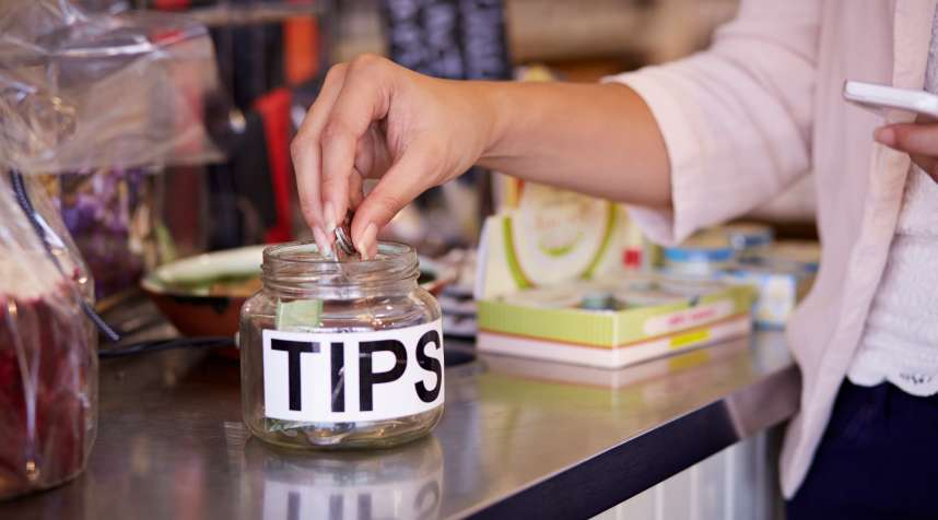 Close-up of woman tipping at café