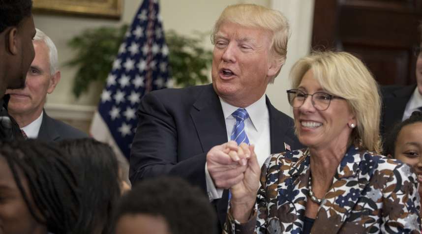 U.S. President Donald Trump, center, shakes hands with Betsy DeVos, U.S. secretary of education, right, during an event for School Choice in the Roosevelt Room at the White House in Washington, D.C., U.S., on Wednesday, May 3, 2017.