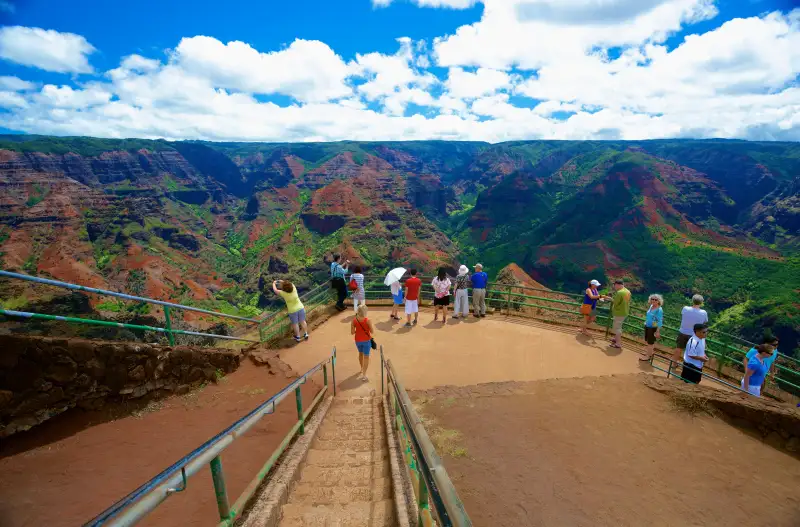 Tourists gather to view the mountainous landscape of Waimea Canyon State Park