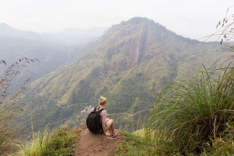 Female tourist enjoying beautiful view of tea plantations, Sri Lanka.