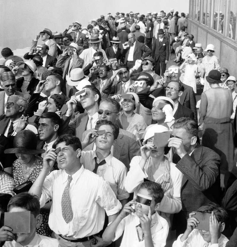 In this Aug. 31, 1932, file photo, eclipse watchers squint through protective film as they view a partial eclipse of the sun from the top deck of New York's Empire State Building in New York.