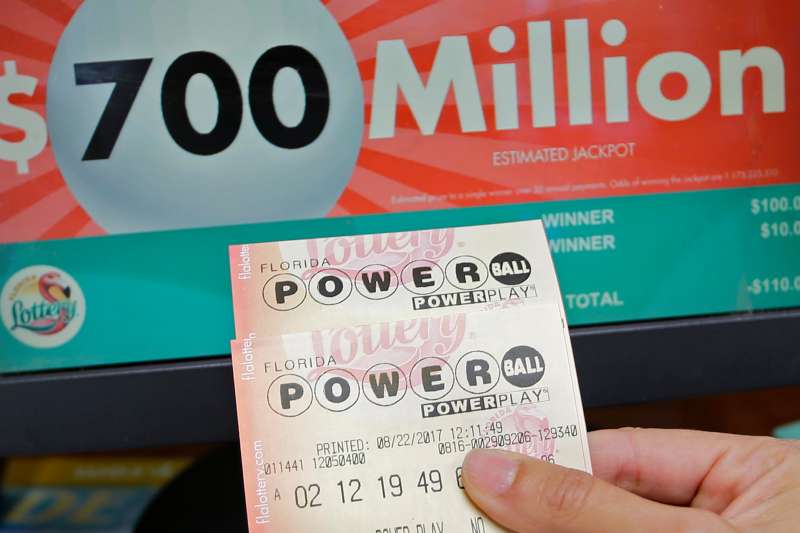 A customer shows her purchased Powerball tickets for Wednesday's drawing, Tuesday, Aug. 22, 2017, in Hialeah, Fla. The winner could take the $700 million annuity option (paid out over 29 years) or the $443.3 million cash prize, minus state and federal taxes.
