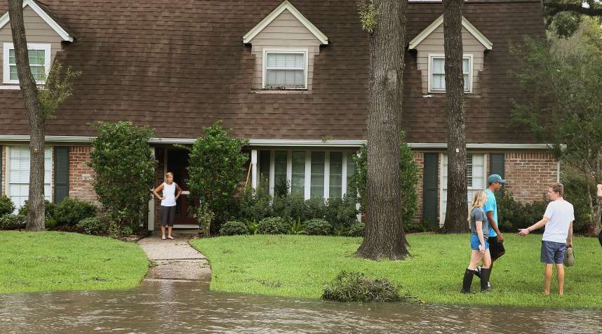 People watch as water continues to rise in their neighborhood following Hurricane Harvey on August 30, 2017 in Houston, Texas.