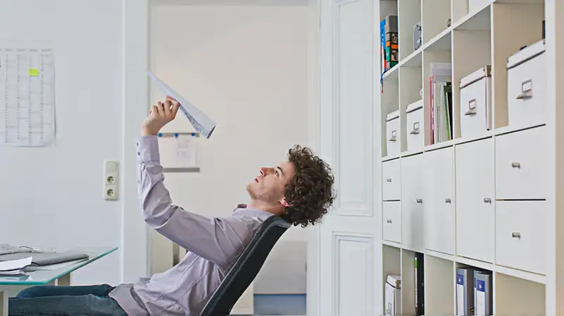 Businessman holding paper airplane