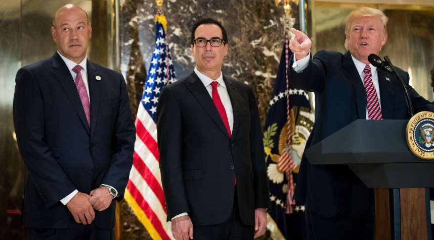Firector of the National Economic Council Gary Cohn (far left) and Treasury Secretary Steve Mnuchin look on as President Donald Trump delivers remarks at Trump Tower in August.