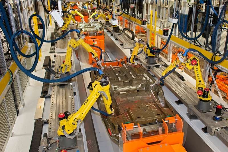 Robots at work in the underbody sealing and underbody coating station of the paint shop at Chrysler's Sterling Heights Assembly Plant, where the company is making the Chrysler 200, Sterling Heights, Michigan, United States, North America