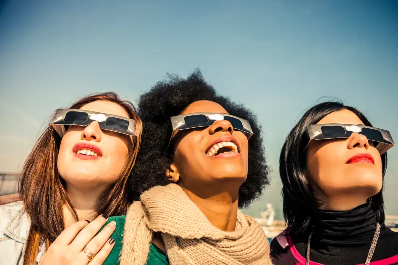 Group of friends looking to a solar eclipse