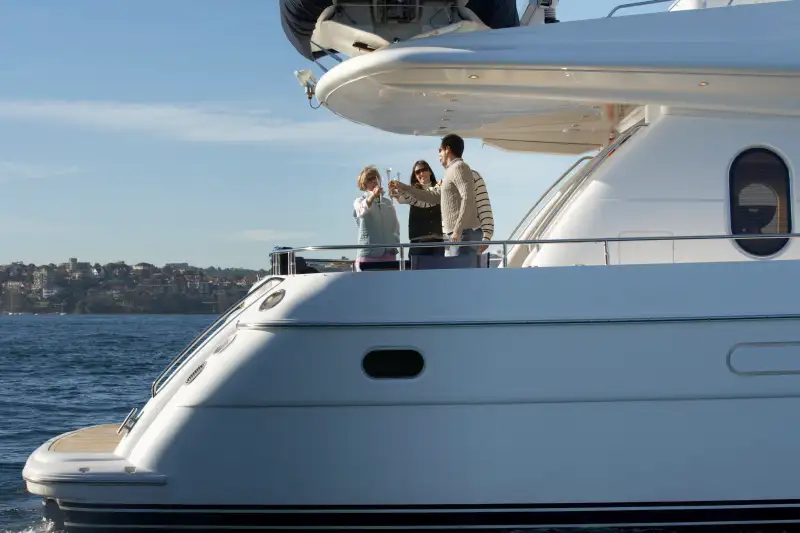 Senior couple and mature couple toasting each other with drinks on yacht