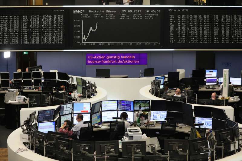 Traders monitor financial data as the DAX index curve shows stock information inside the Frankfurt Stock Exchange, operated by Deutsche Boerse AG, in Frankfurt, on Sept. 25, 2017.