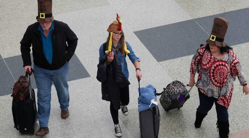 From left, Jack, Nikki  and Rae Forbes of Asheville, N.C., wear hats to fit the holiday as they head through the terminal after arriving at Denver International Airport early Wednesday, Nov. 23, 2016, in Denver. Travelers are criss-crossing the country Wednesday, clogging airport terminals in a rush to reach their Thanksgiving Day destinations.