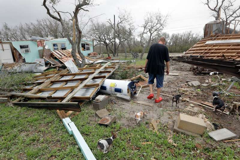 Sam Speights walks with his dogs as he checks on the damage to his home in the wake of Hurricane Harvey, Sunday, Aug. 27, 2017, in Rockport, Texas. Speights tried to stay in his home during the storm but had to move to other shelter after his lost his roof and back wall.