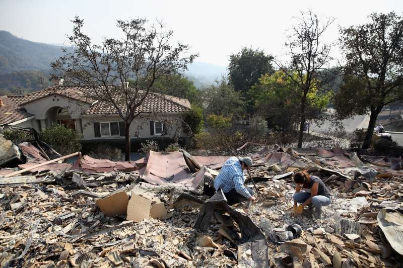 Brad Turley and Charisse Desmarais look through the remants of her mother's home in the Silverado Community, which was burned by the Atlas Fire on October 10, 2017 in Napa, California. Fifteen people have died in wildfires that have burned tens of thousands of acres and destroyed over 2,000 homes and businesses in several Northen California counties.