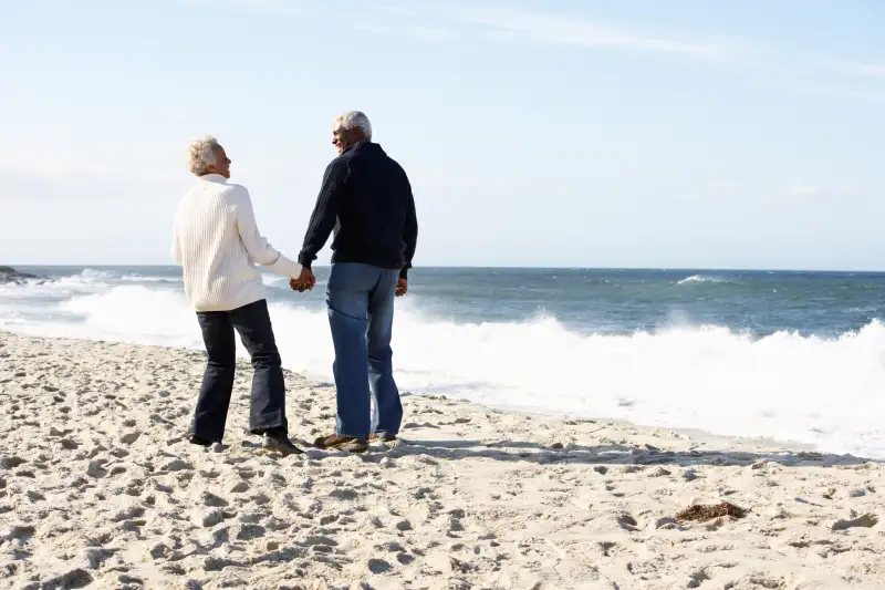 Senior couple walking beach together