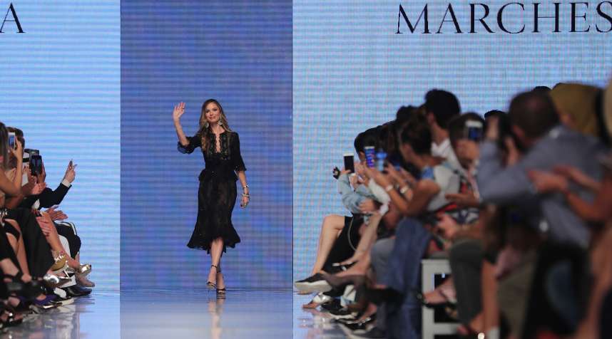 Fashion designer Georgina Chapman, co-founder of Marchesa, waves to the audience on the cat walk after her shows during the Arab Fashion Week in the United Arab Emirate of Dubai on May 16, 2017.