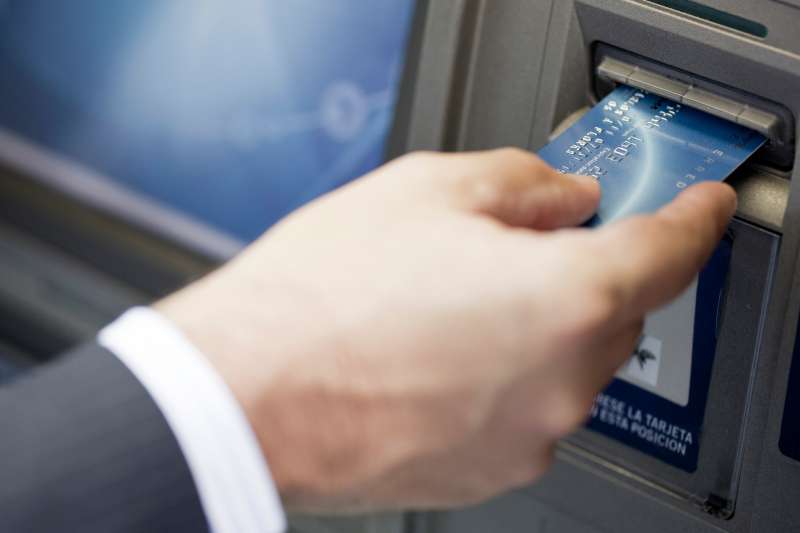 Inserting bank card into ATM to perform automated banking transaction