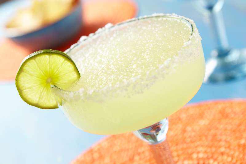 Frozen margarita with salt on rim and lime slice.