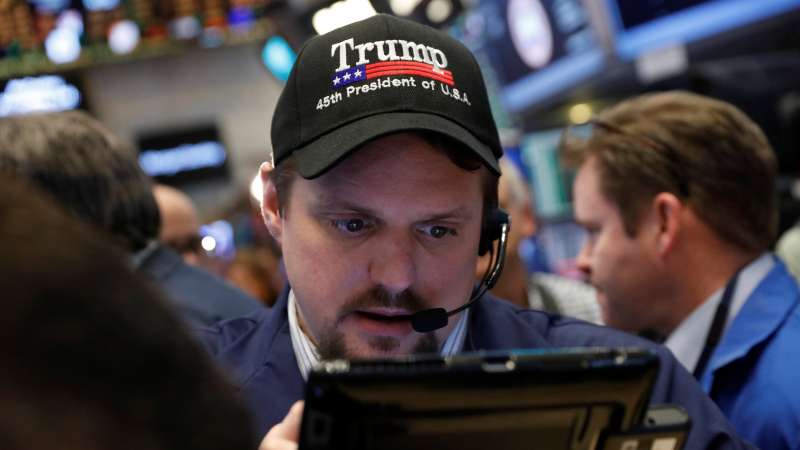 A trader wears a Donald Trump hat while working on the floor of the NYSE shortly after the opening bell in New York