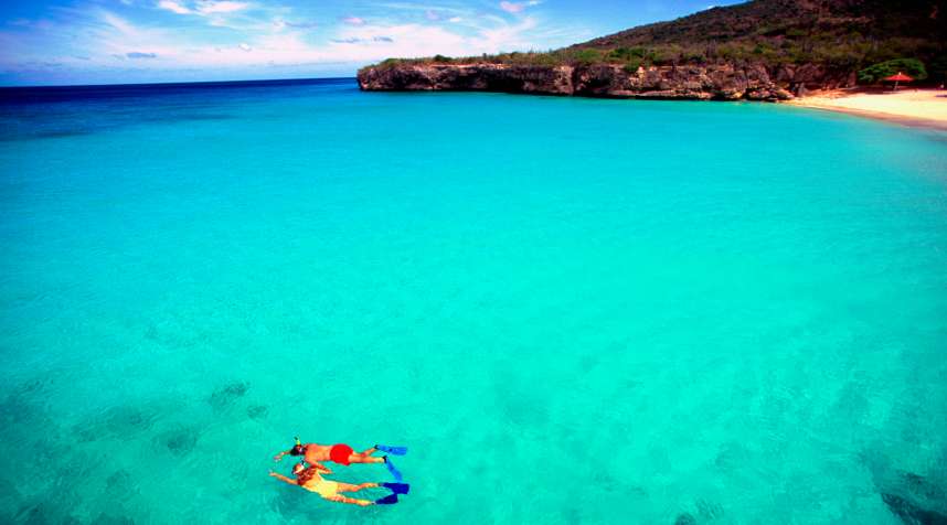 Couple snorkeling in crystal clear water off Knip Beach in Curacao.