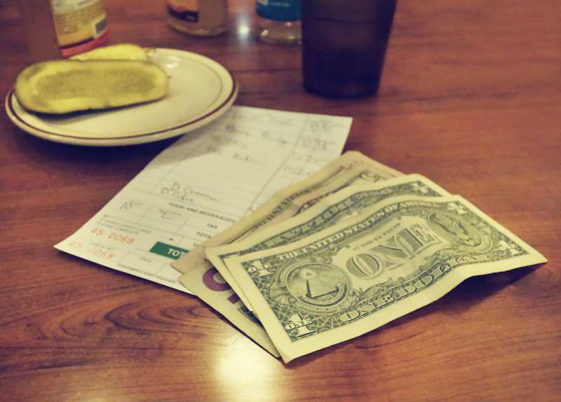 Restaurant bill on table, money left beside it