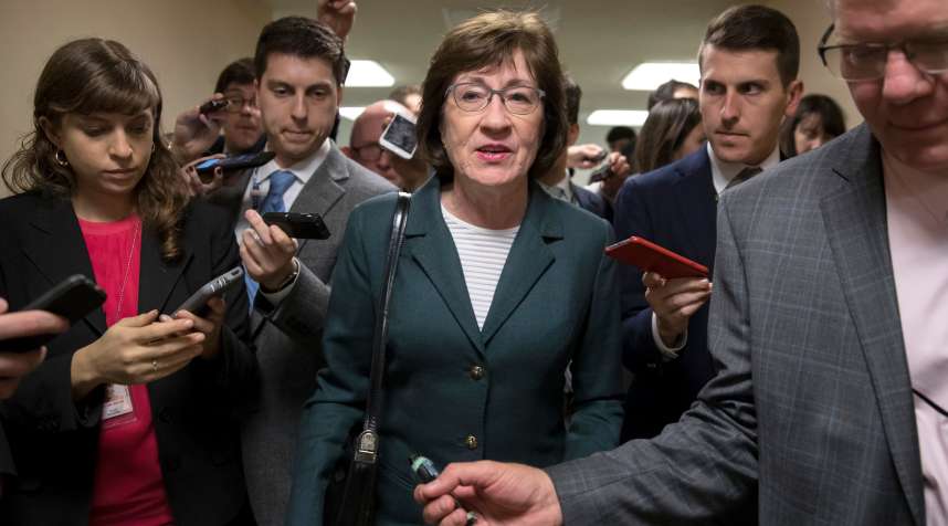 In this Nov. 30, 2017, file photo, with reporters looking for updates, Sen. Susan Collins, R-Maine, and other senators rush to the chamber to vote on amendments as the Republican leadership works to craft their sweeping tax bill in Washington.