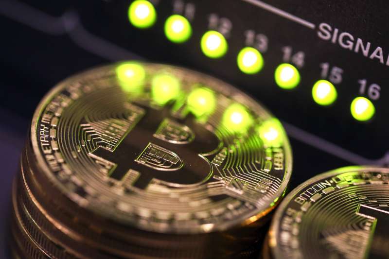Stacks of bitcoins sit near green lights on a data cable terminal at an office in Sept. 2017.