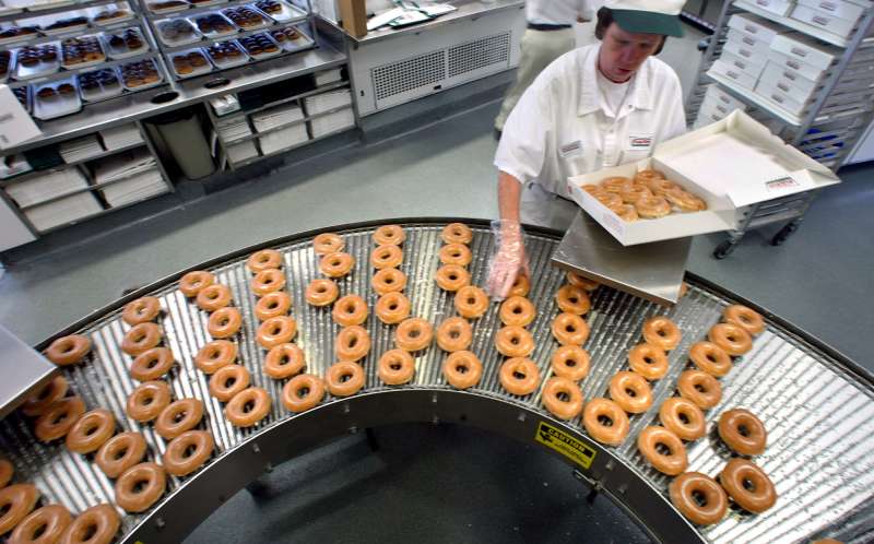 This is a profile of the Krispy Kreme chain. Here, Gloria Yates boxes a dozen original glazed doughn