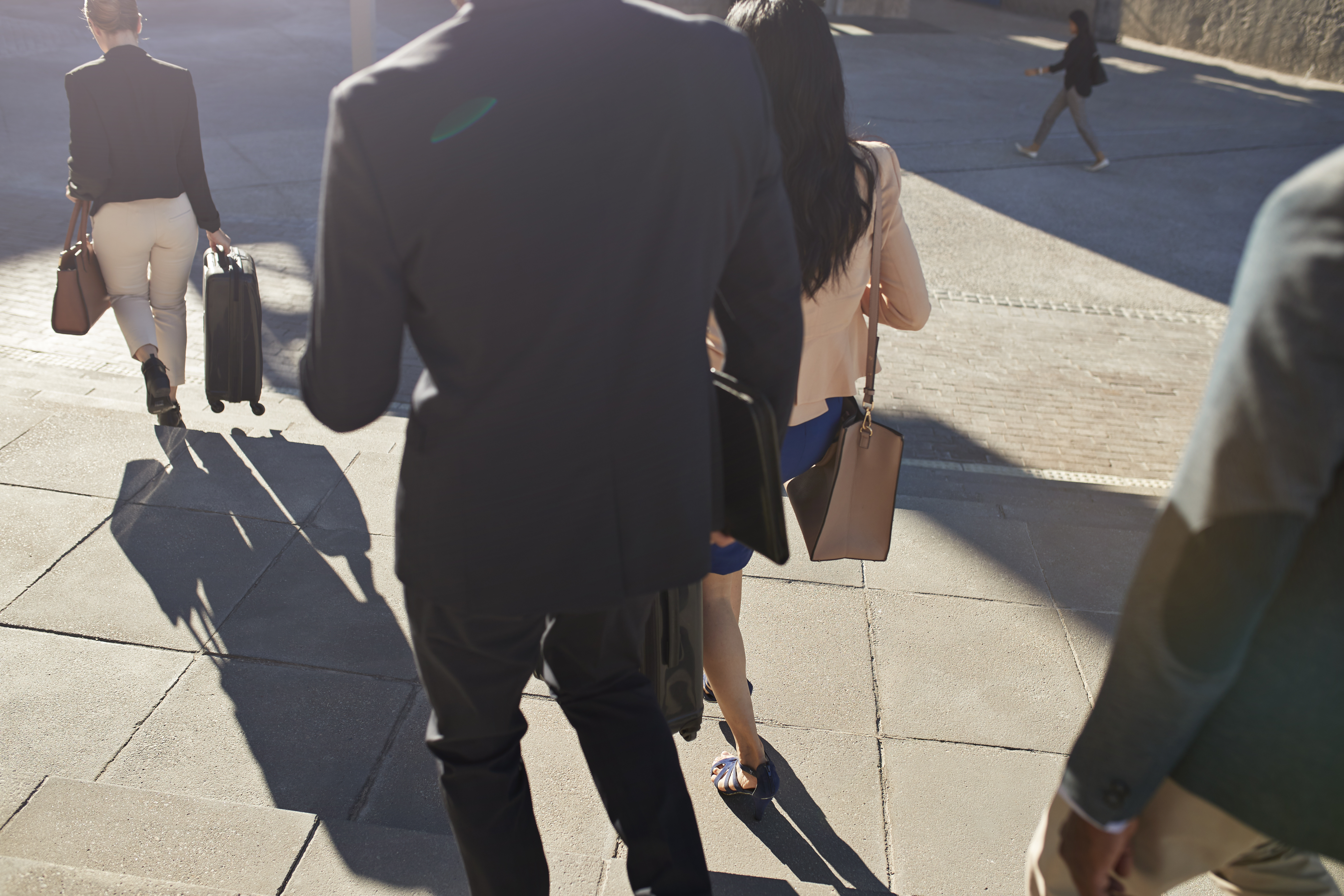 Businesspeople walking on staircase with bags
