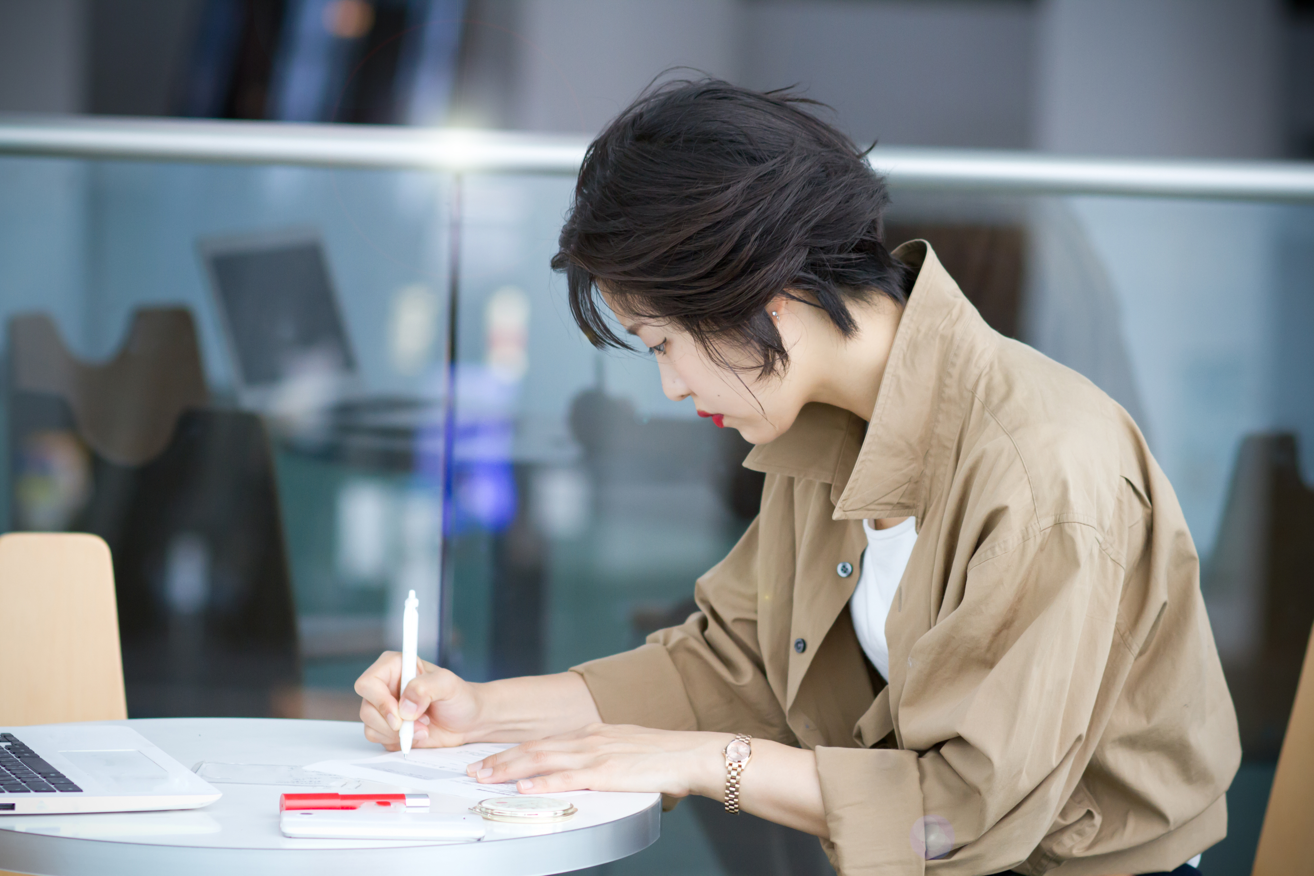 Woman taking notes at her desk.