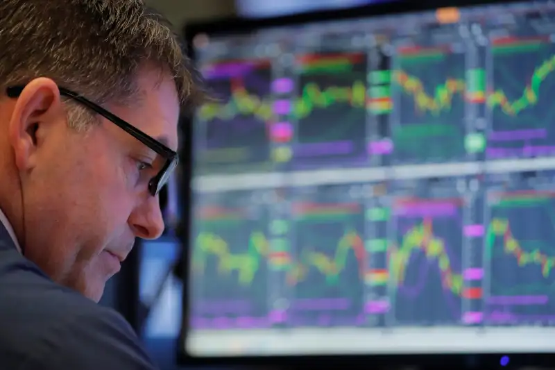 A trader works on the floor of the New York Stock Exchange shortly after the opening bell in New York