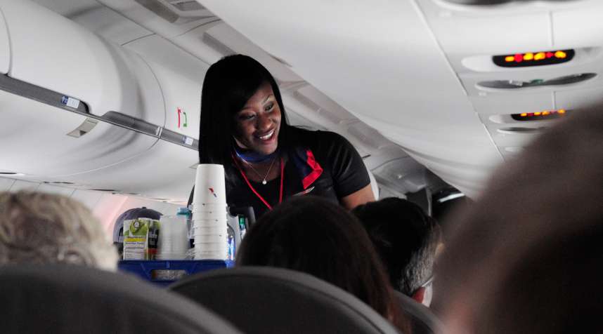 An American Airlines flight attendant serves drinks to passengers after departing from Dallas/Fort Worth International Airport in Texas.