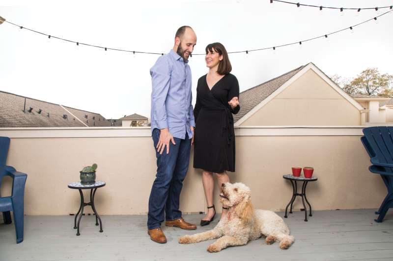 Warren and Lauren Hicks with their golden doodle, Ravi, on the terrace of their Houston condo.
