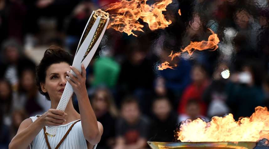 Actress Katerina Lechou, performing a high priestess lights a torch at The Panathenaic Stadium in Athens on October 31, 2017, during the handover ceremony of the Olympic flame for the 2018 Winter Olympics in Pyeongchang, South Korea.