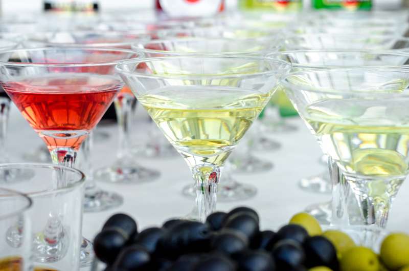 Glasses of martini with olives and glasses with cognac. Alcoholic beverages served at bar. Club atmosphere.