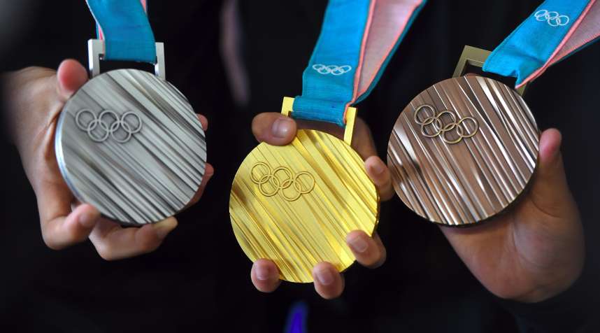 The PyeongChang 2018 Olympic medals are displayed by young South Korean athletes during their unveiling at a ceremony in Seoul on September 21, 2017. The Olympic Winter Games PyeongChang 2018 medals were officially unveiled on September 21, with features of the Korean alphabet consonants on their bodies.