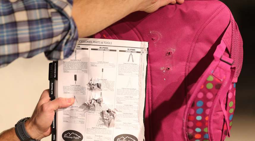 A book and the back of a child's bulletproof backpack are displayed with the effects of bullets that were shot through it without Amendment II's Rynohide CNT Shield on December 21, 2012 in Salt Lake City, Utah.