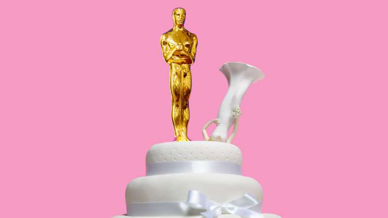 Oscar statuette on top of wedding cake with bride upside down