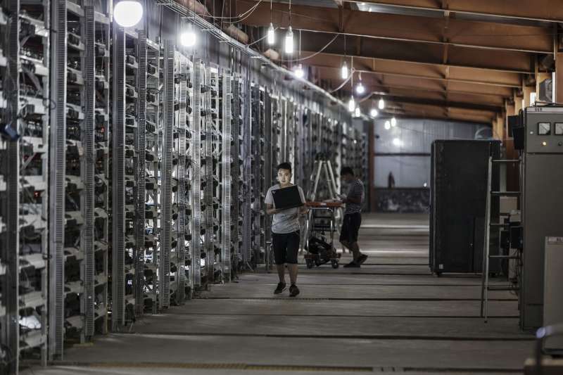 Technicians inspect bitcoin mining machines at a mining facility operated by Bitmain Technologies Ltd. in Ordos, Inner Mongolia, China, on Friday, Aug. 11, 2017.
