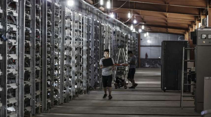 Technicians inspect bitcoin mining machines at a mining facility operated by Bitmain Technologies Ltd. in Ordos, Inner Mongolia, China, on Friday, Aug. 11, 2017.