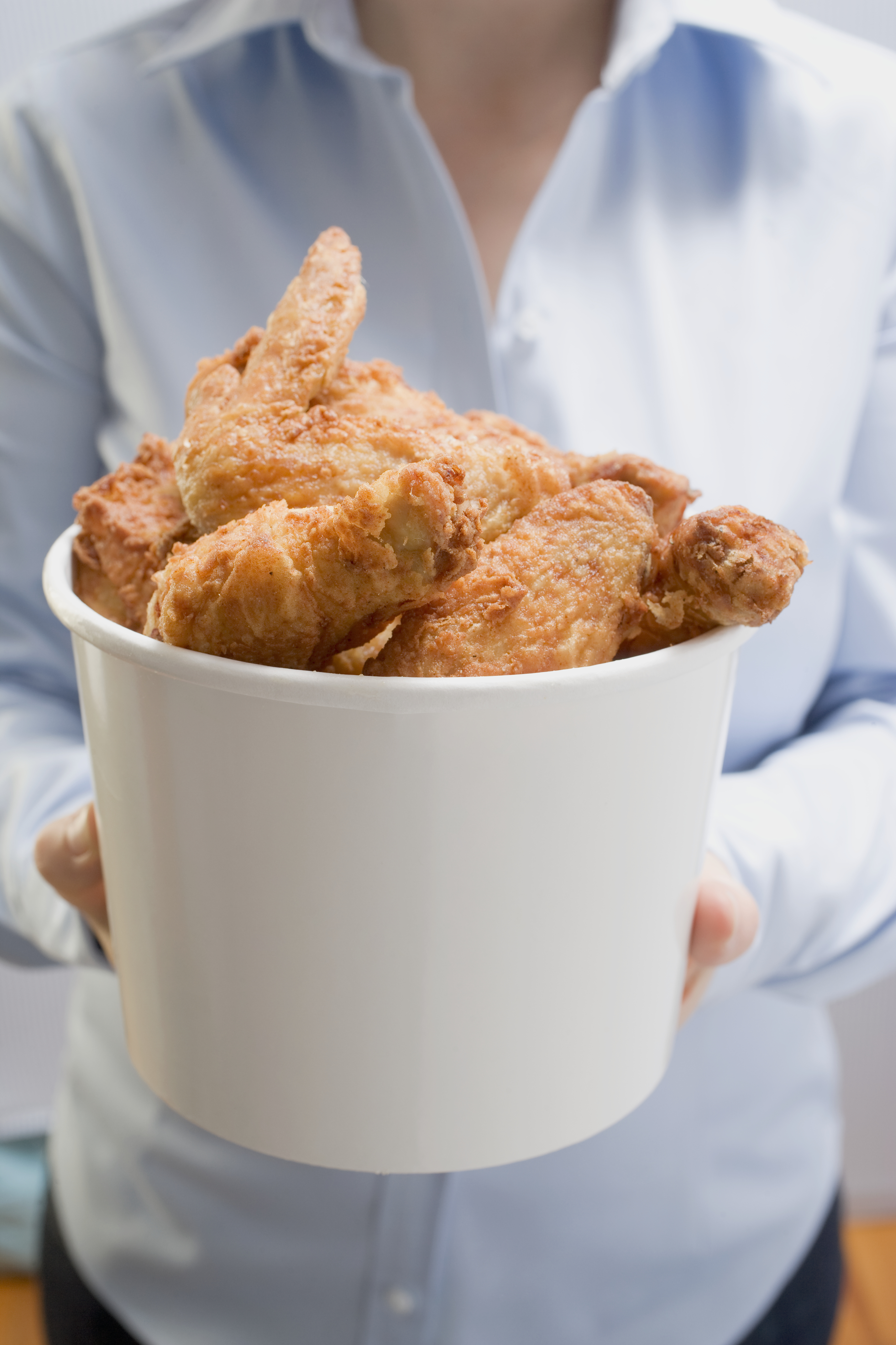 Woman holding deep-fried chicken pieces, close up