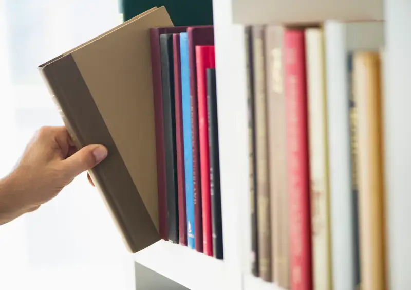 Hand choosing book from shelf