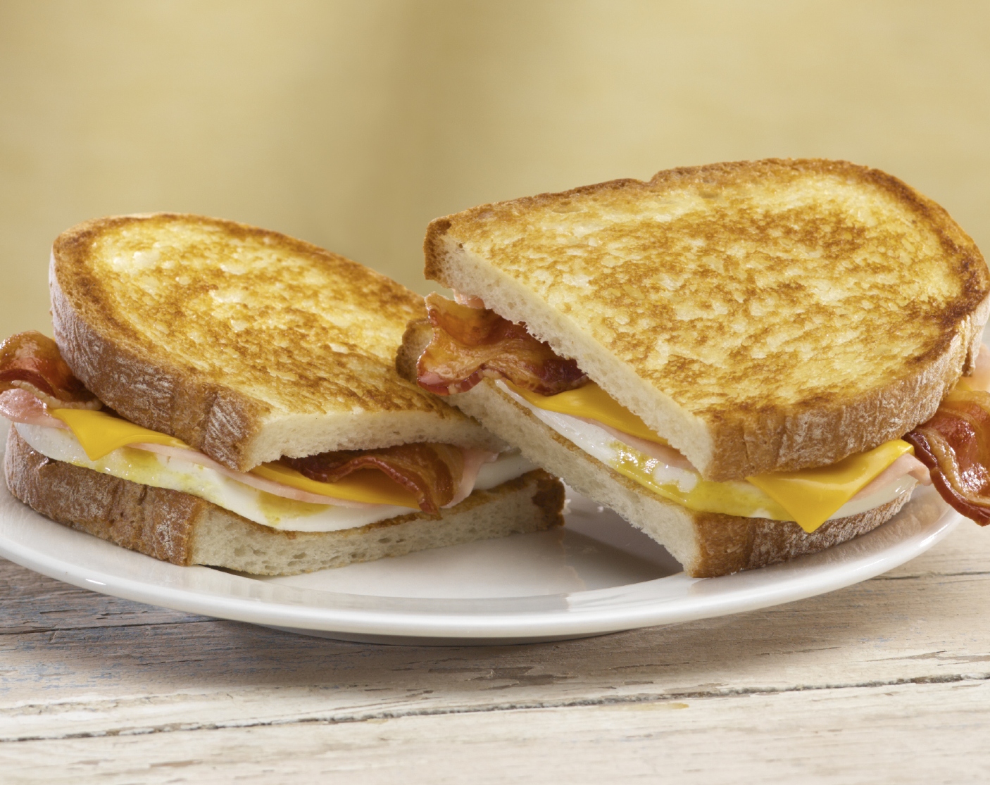 Grilled Breakfast Sandwich from Jack-in-the-box. With two freshly cracked eggs, two slices of ham, two strips of bacon and two slices of melting American cheese all on grilled artisan bread.