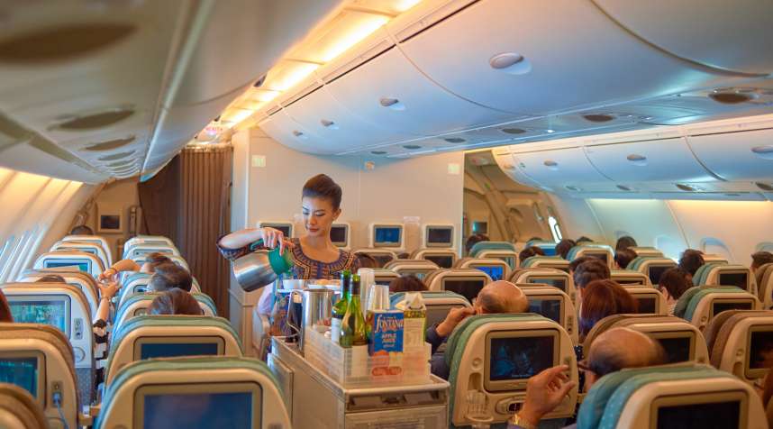 A flight attendant serves food and drinks to passengers on board of Singapore Airlines Airbus A380, November 3, 2015.