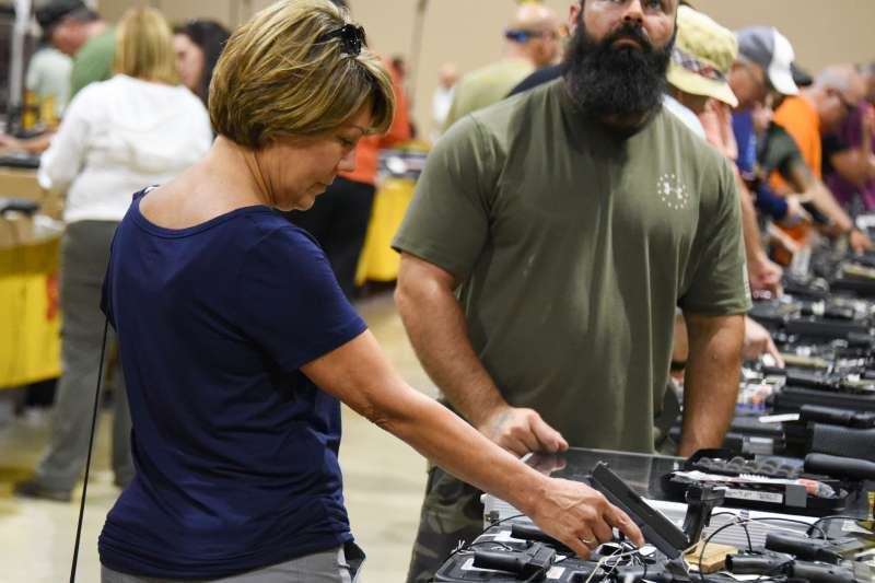 A gun enthusiast holds a weapon during the South Florida Gun Show at Dade County Youth Fairgrounds in Miami, Florida, on February 17, 2018