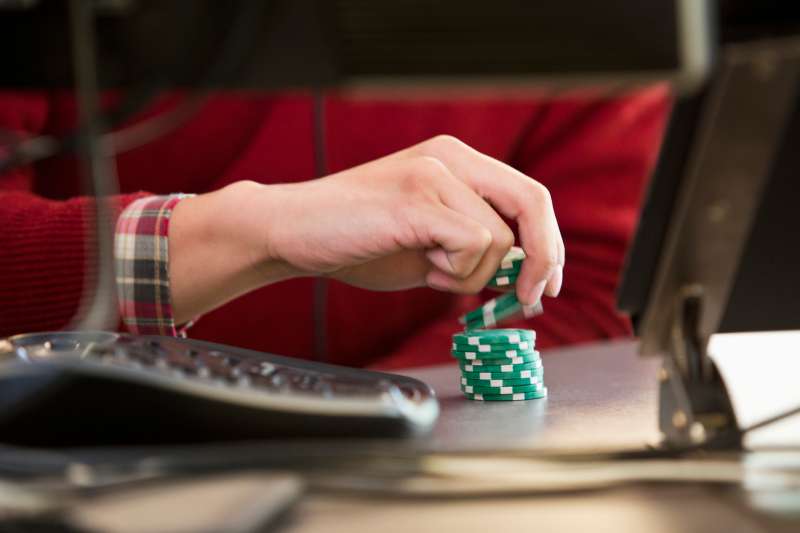 Vietnamese businessman with poker chips at office desk