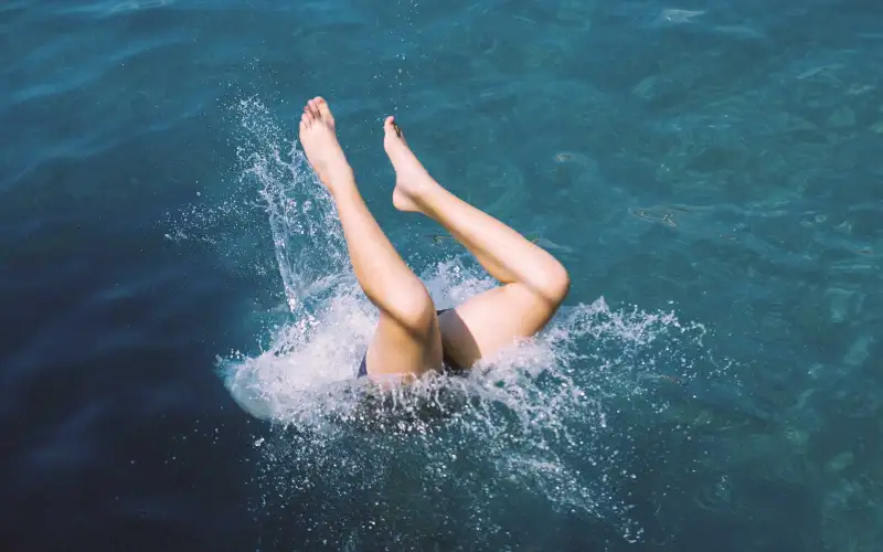 Caucasian teenage girl diving into water