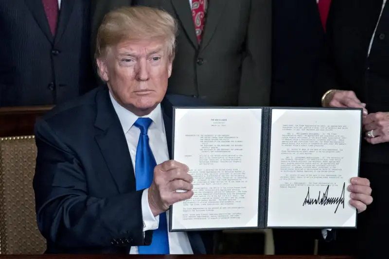 U.S. President Donald Trump holds up a signed presidential memorandum targeting China's economic aggression in the Diplomatic Room of the White House in Washington, D.C., U.S., on Thursday, March 22, 2018. Trump announced about $50 billion of tariffs against China over intellectual-property violations opening a new front in an escalating global trade skirmish that is shaking financial markets.